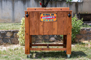Close-up of vintage cold drinks wooden cooler at outdoor catering