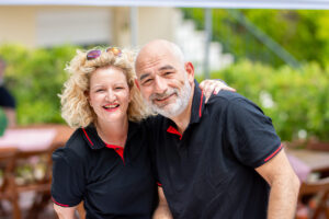 Smiling BBQ catering staff in black uniforms at Texas smoked BBQ event