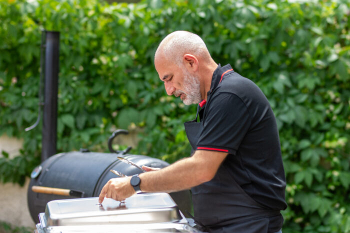 BBQ chef preparing Texas smoked meats at outdoor catering buffet