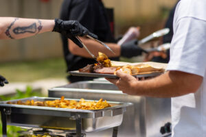 BBQ buffet serving line with smoked brisket, sides, and bread at catering