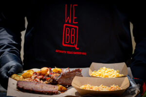 BBQ plate with sliced brisket, pulled pork, roasted potatoes, mac and cheese and coleslaw